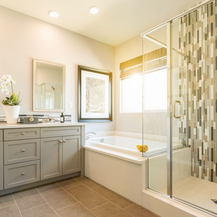 Glass shower enclosure with a vertical mosaic tile feature strip