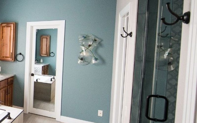 Shower with glass door and vertical tile accent