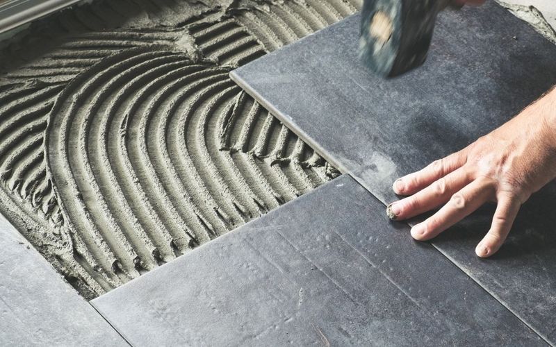 Large-format tile being set into thinset mortar