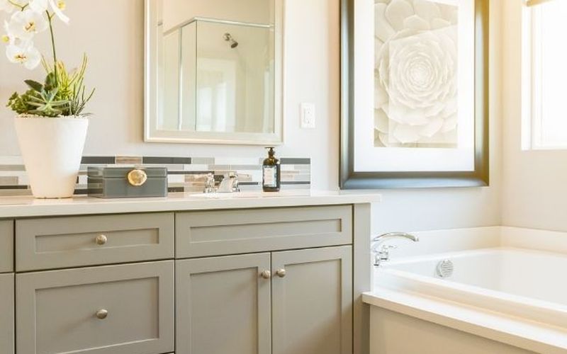 Bathroom vanity with framed mirror and alcove tub