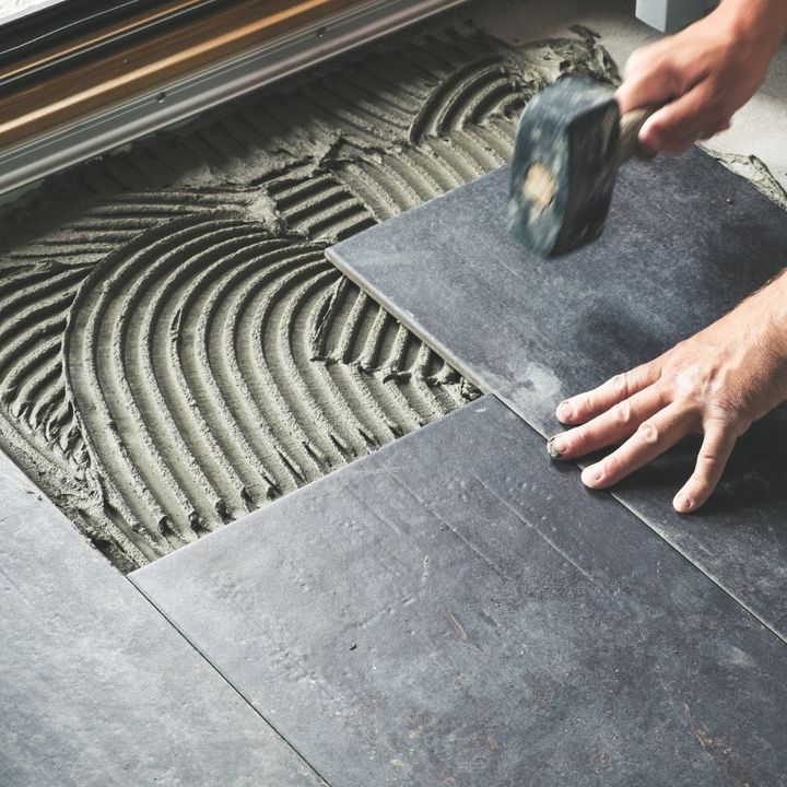 Large-format tile being set into combed thinset